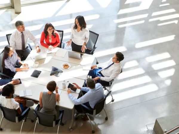 Cerrar la brecha entre liderazgo y empleados en la adopción de la IA Equipo de profesionales colaborando en un entorno corporativo mientras analizan información y herramientas digitales. La imagen representa la necesidad de alinear liderazgo, formación y adopción tecnológica para impulsar el uso de la inteligencia artificial en toda la organización.