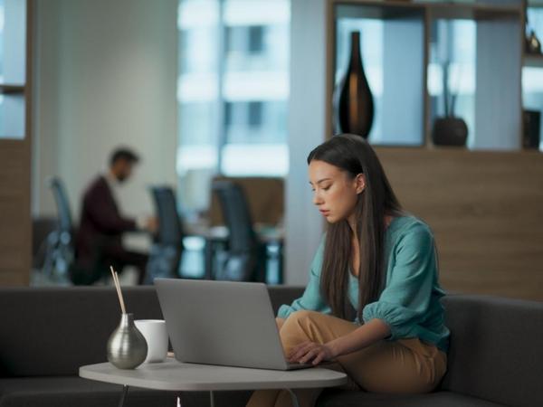 Persona utilizando un asistente de inteligencia artificial desde un ordenador portátil mientras analiza información en un entorno de trabajo digital. La imagen representa la creciente interacción entre las personas y la IA para comunicarse, aprender y resolver problemas.