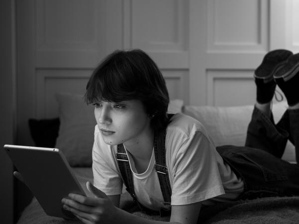 Grupo de adolescentes utilizando teléfonos móviles y plataformas digitales para comunicarse e interactuar. La imagen representa cómo las relaciones sociales y la conexión digital forman parte del ecosistema tecnológico y económico actual.