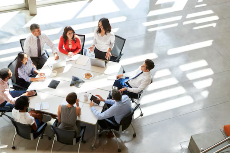 Equipo de profesionales colaborando en un entorno corporativo mientras analizan información y herramientas digitales. La imagen representa la necesidad de alinear liderazgo, formación y adopción tecnológica para impulsar el uso de la inteligencia artificial en toda la organización.