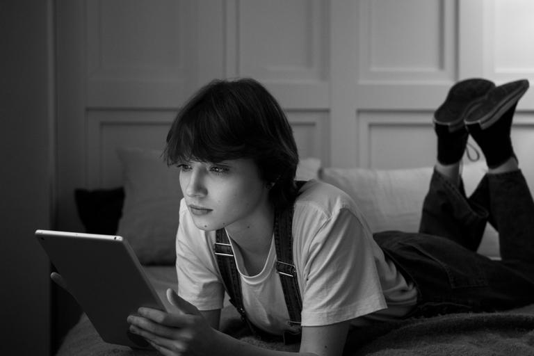 Grupo de adolescentes utilizando teléfonos móviles y plataformas digitales para comunicarse e interactuar. La imagen representa cómo las relaciones sociales y la conexión digital forman parte del ecosistema tecnológico y económico actual.