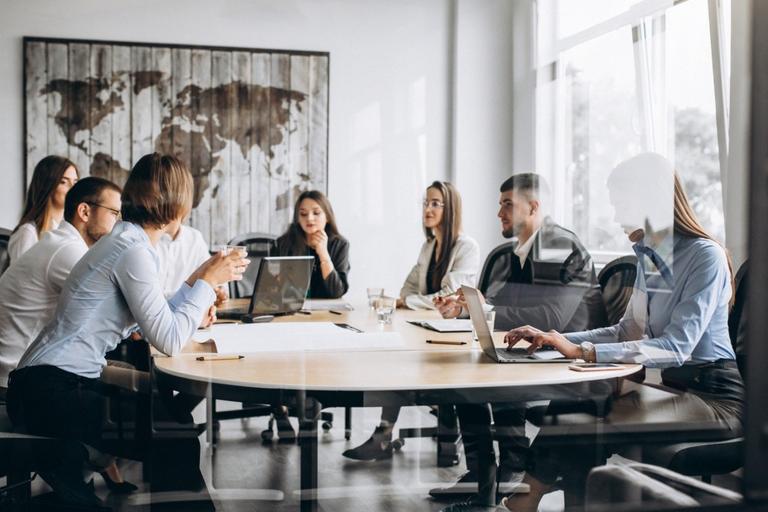 Equipo de profesionales analizando procesos de trabajo mediante herramientas digitales e inteligencia artificial. La imagen representa la transformación de los modelos operativos y la redefinición de procesos impulsada por la adopción de la IA.