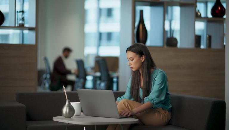Persona utilizando un asistente de inteligencia artificial desde un ordenador portátil mientras analiza información en un entorno de trabajo digital. La imagen representa la creciente interacción entre las personas y la IA para comunicarse, aprender y resolver problemas.