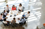 Equipo de profesionales colaborando en un entorno corporativo mientras analizan información y herramientas digitales. La imagen representa la necesidad de alinear liderazgo, formación y adopción tecnológica para impulsar el uso de la inteligencia artificial en toda la organización.